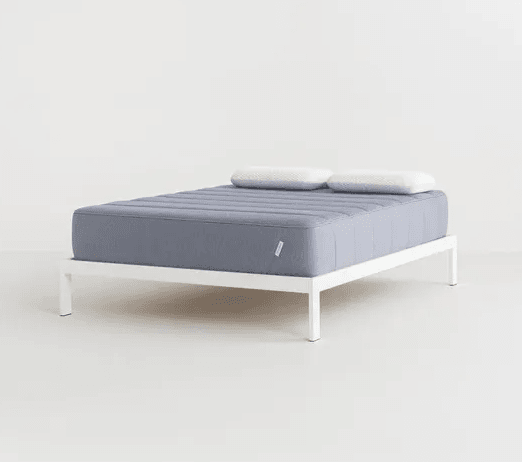 A Tuft & Needle hybrid mattress against a gray background.