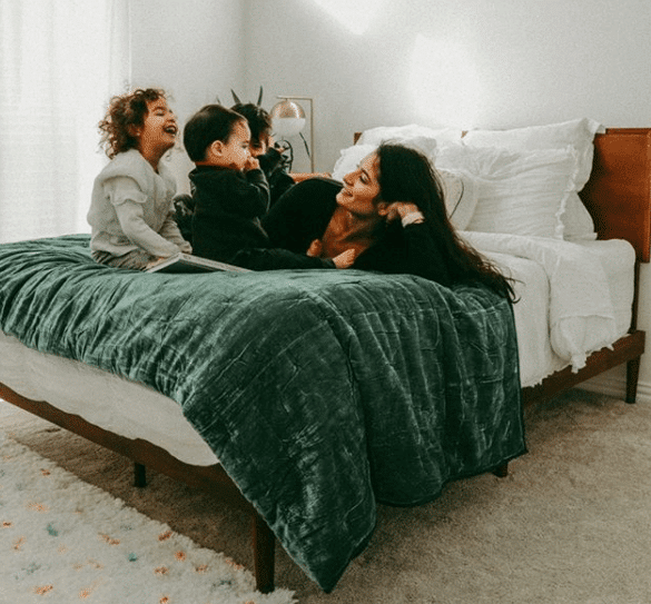 A woman and her children rest on top of a Zinus mattress.