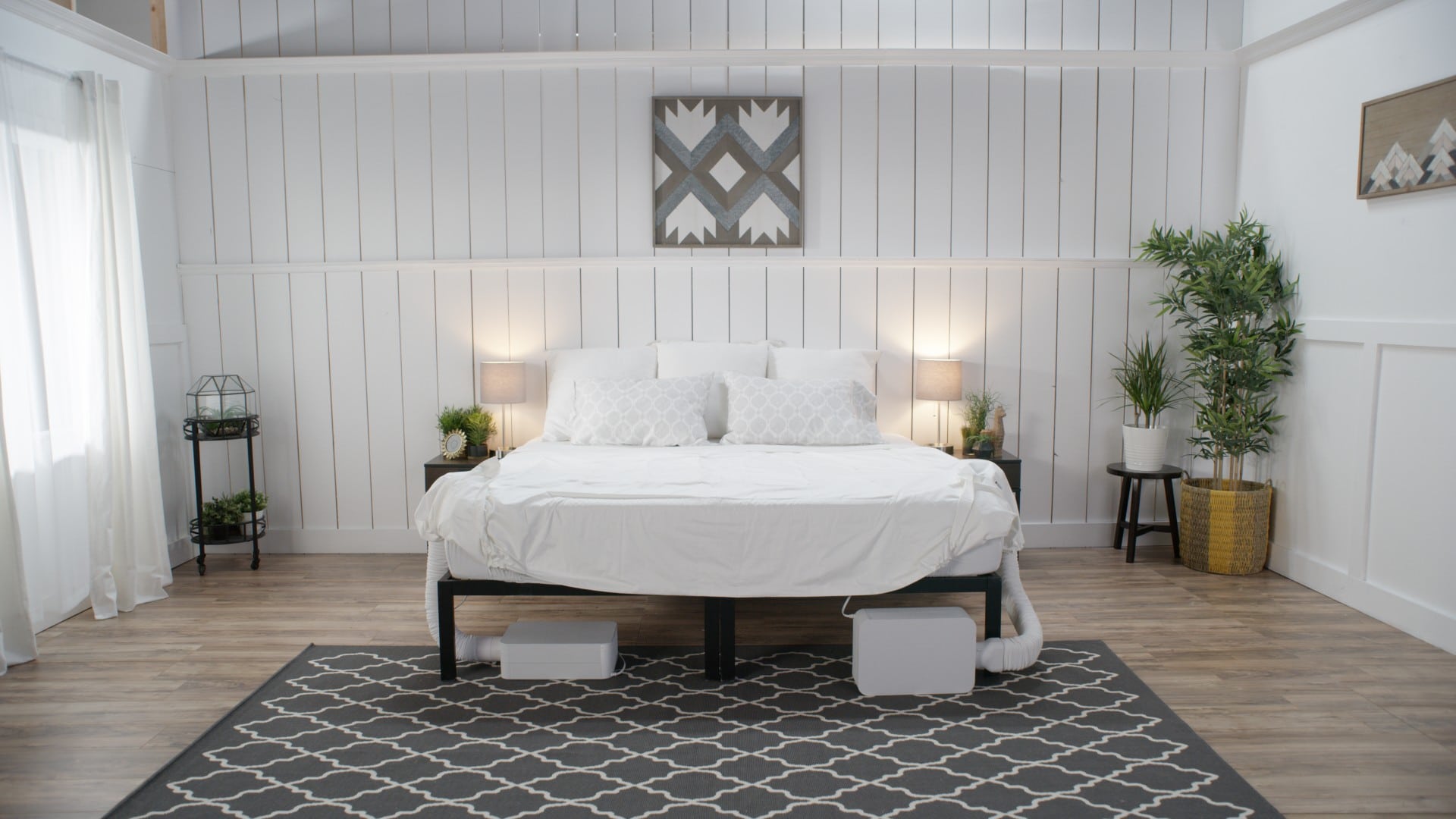 A white bedroom with a white bed and two BedJets.