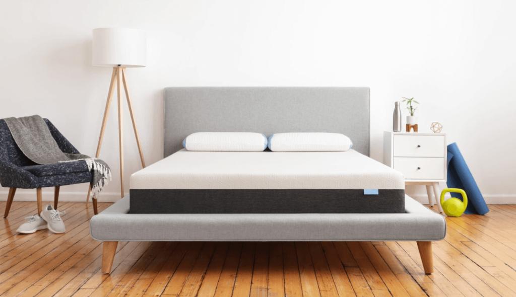 A gray and white Bear mattress on a gray bed frame.