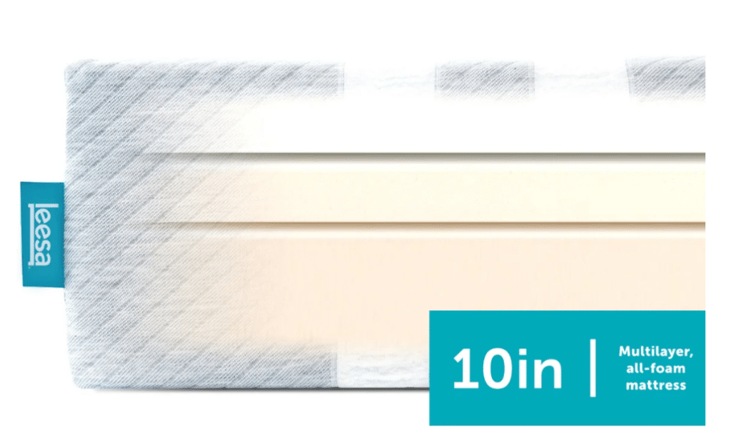 A tri-layer foam mattress with a gray and white striped outer cover and a turquoise tag.