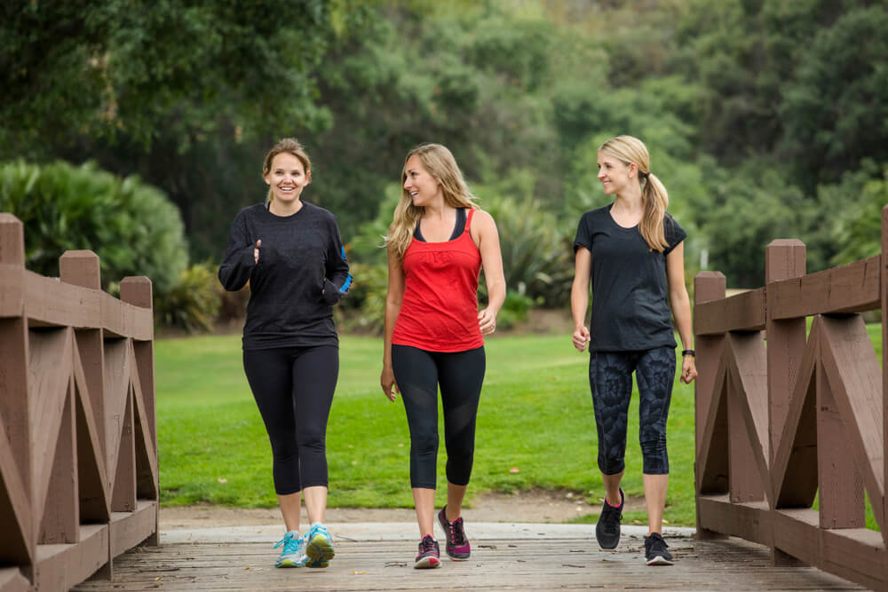 Group of women in their 30s walking together in the outdoors. Cute blond and fit women in their mid 30s who are active and working to stay healthy.