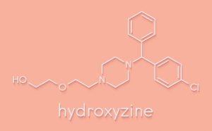 A white chemical outline of Hydroxyzine, or Vistaril, on a pink background.