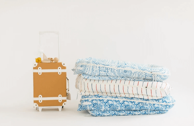 Dock-A-Tots are easy to transport. Suitcase next to stack of baby loungers.