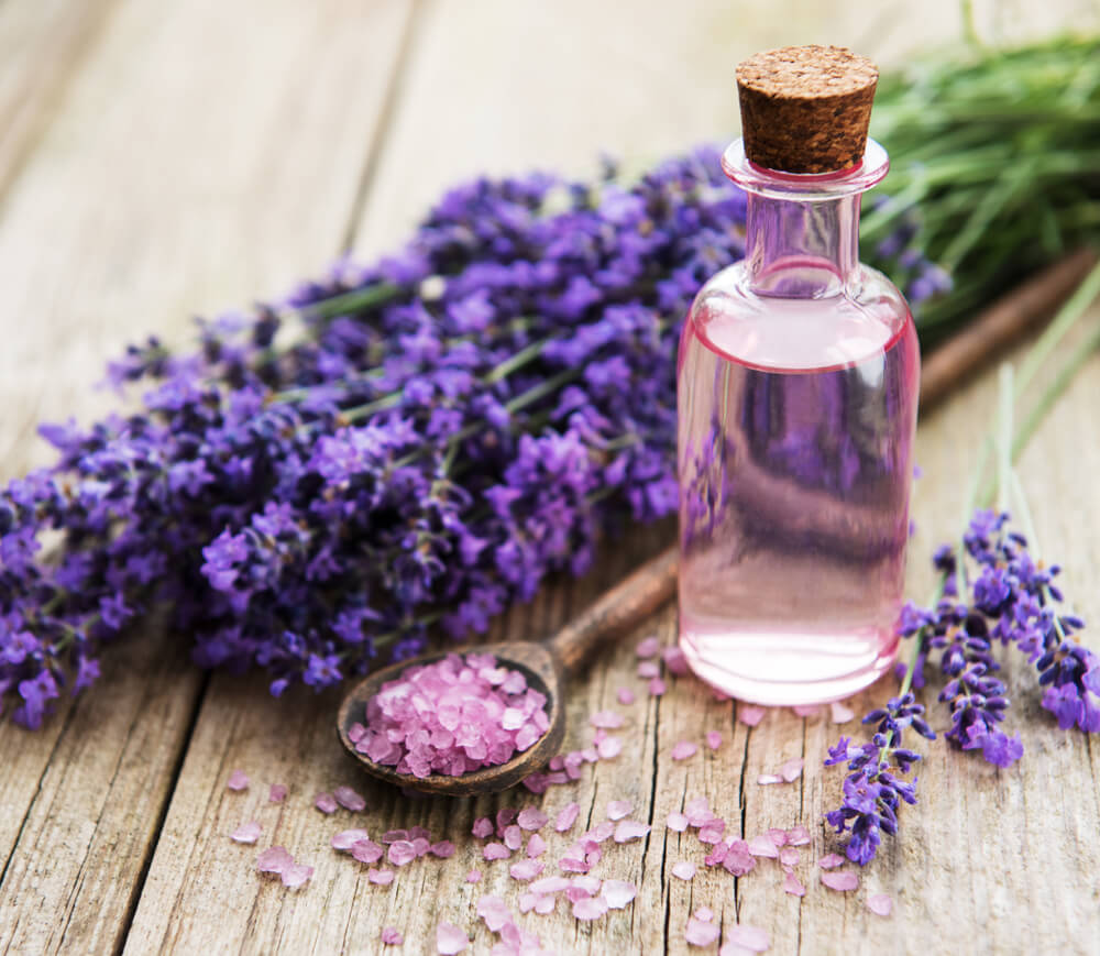 sea salt, essential oils and fresh lavender flowers on a old wooden background