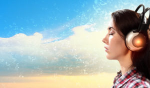 Image of young pretty woman with headphones with eyes closed. Side view, listening to white noise