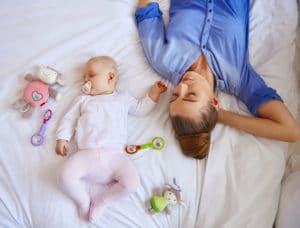 Mother and baby laying down and sleeping.