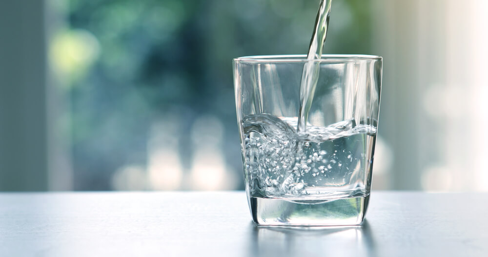 A glass of water on a counter top.