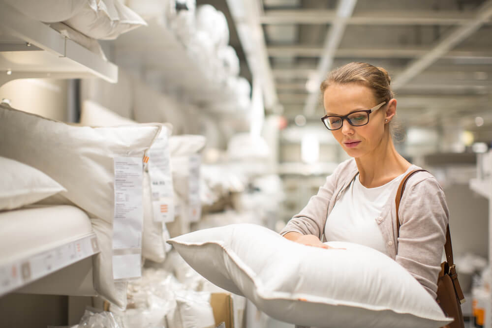 A woman examines a pillow to ease her earaches.