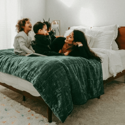 A woman and her children rest on top of a Zinus mattress.