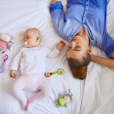Mother and baby laying down and sleeping.
